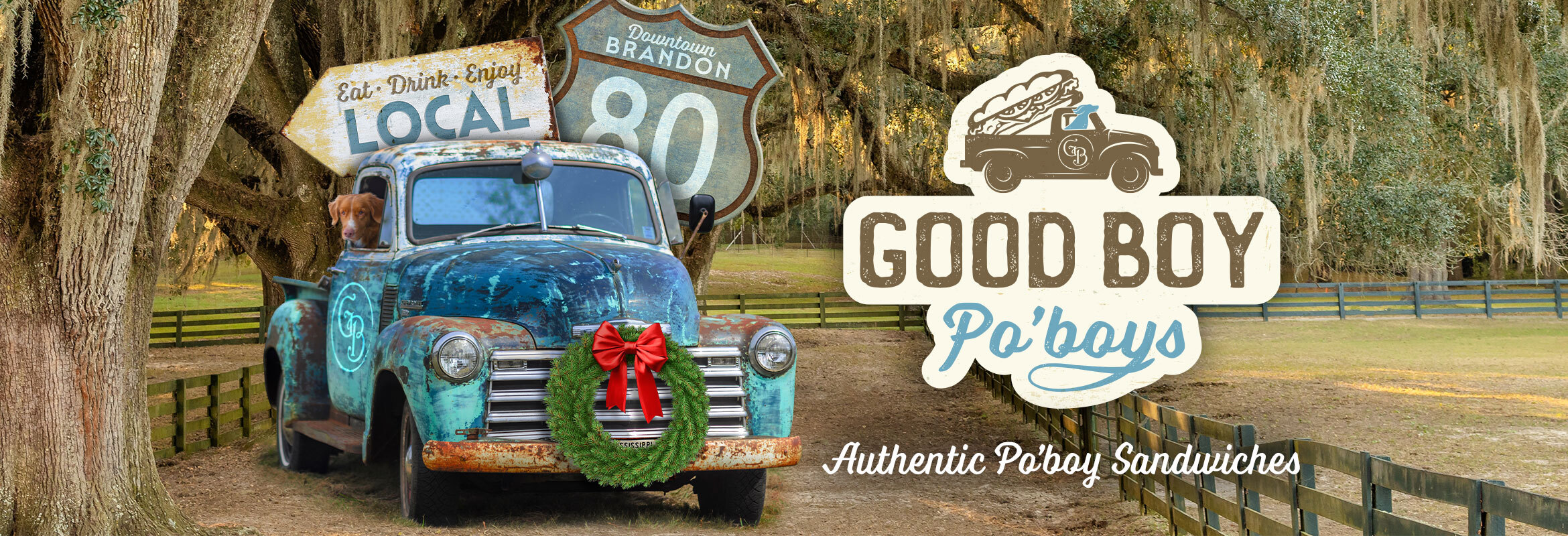 Good Boy Po'boys logo. Antique truck with dog leaning out passenger window, parked in front of trees with Spanish moss. Road signs reading: Eat, Drink Enjoy. Local. Downtown Brandon. 80. Additional Text: Good Boy Po'boys. Authentic Po'boy Sandwiches.